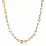 A yellow gold tennis necklace featuring baguette, round, marquise, and teardrop-cut clear gemstones, displayed on a clean white background.