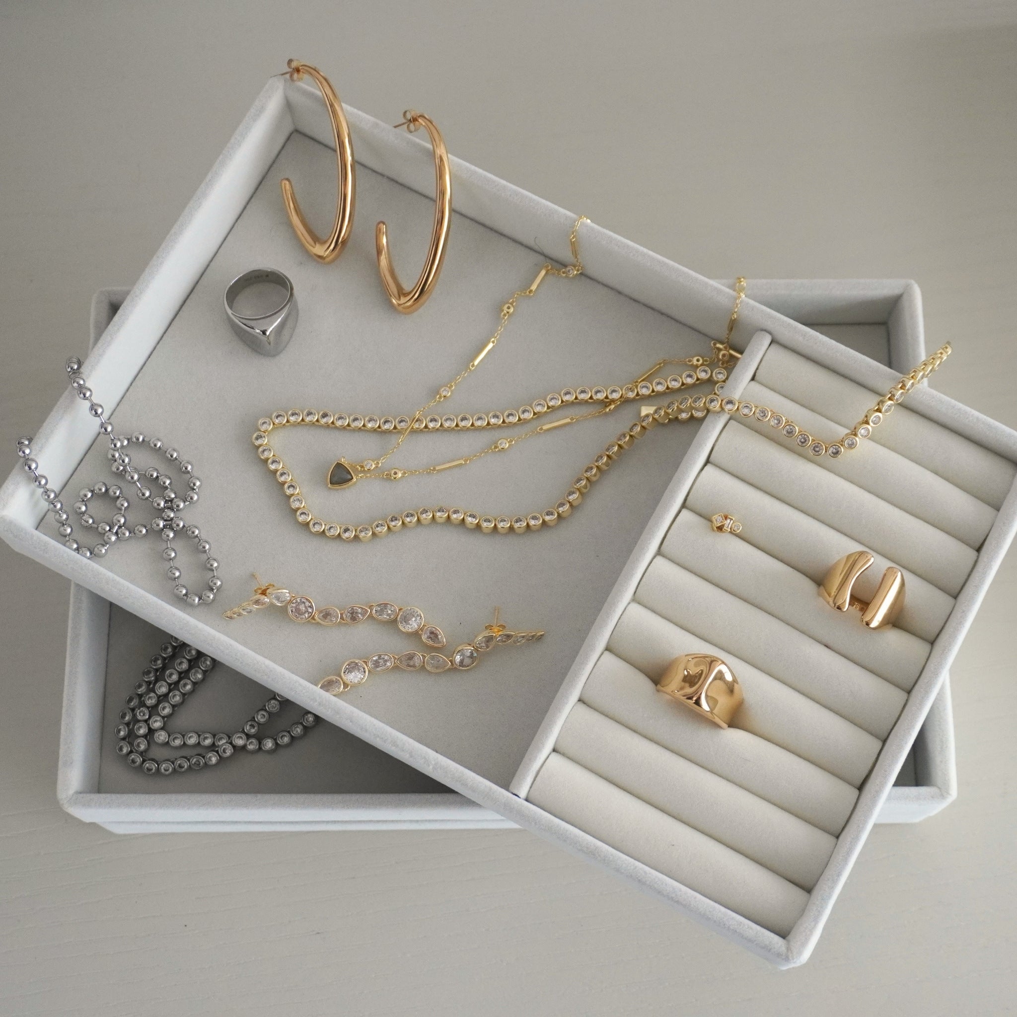 Large gold elongated hoop earrings styled in ear stack with studs and ear cuff – Nikki E. Designs