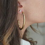 Large gold elongated hoop earrings styled in ear stack with studs and ear cuff – Nikki E. Designs