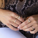 Gold baguette crown ring stacked with Evil Eye ring on hand in denim – Nikki E. Designs