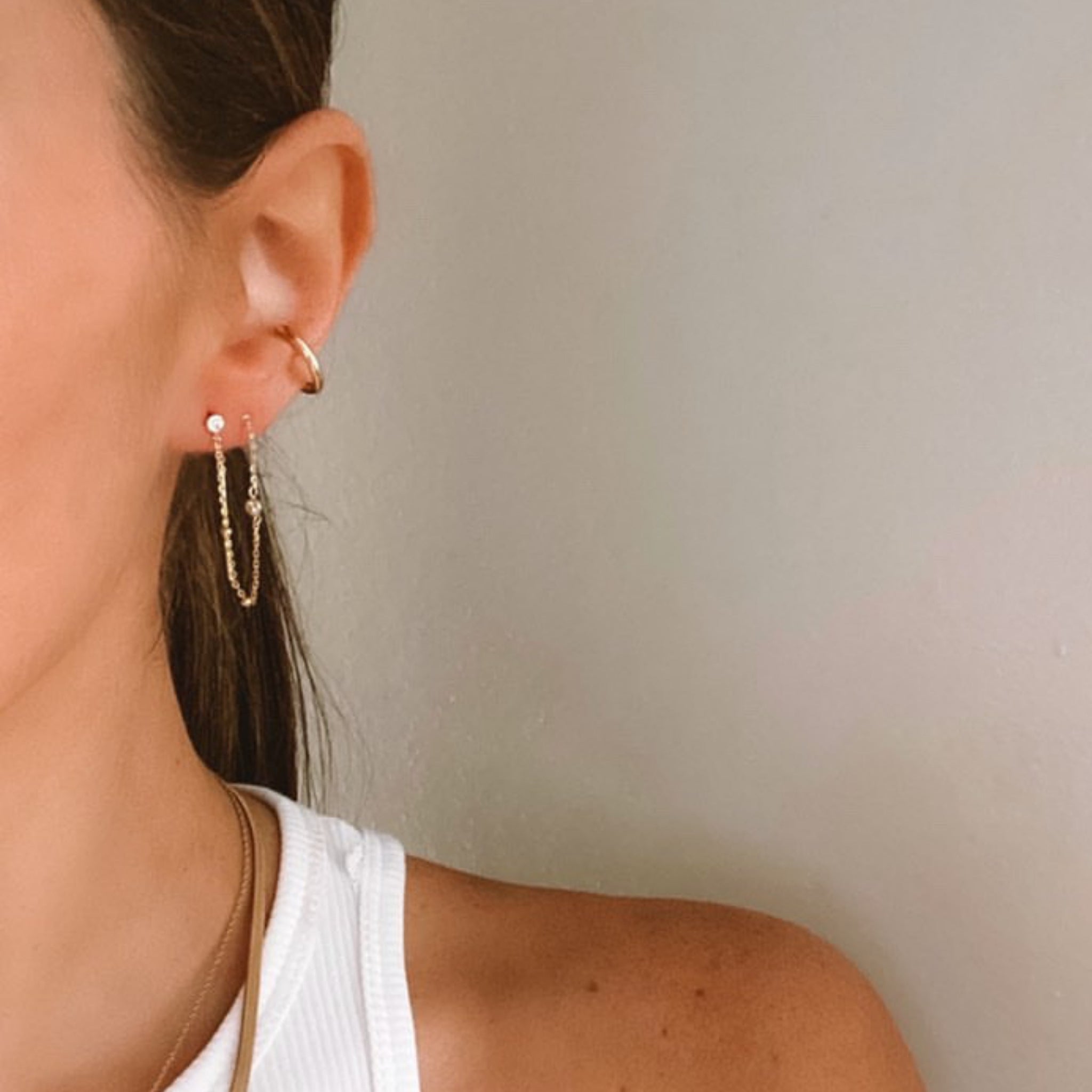 Gold satellite chain threader earrings worn through two piercings in ear stack – Nikki E. Designs
