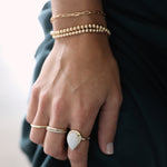 Gold bead stretch bracelets stacked on wrist with tennis bracelet and bangles – Nikki E. Designs